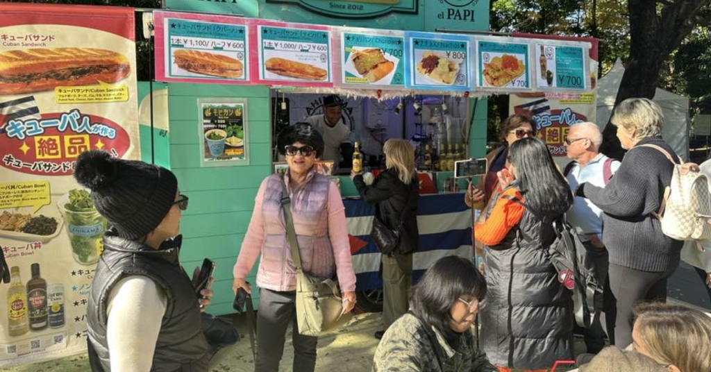 Food truck de cafetería cubana en Japón decorado con banderas y colores caribeños.